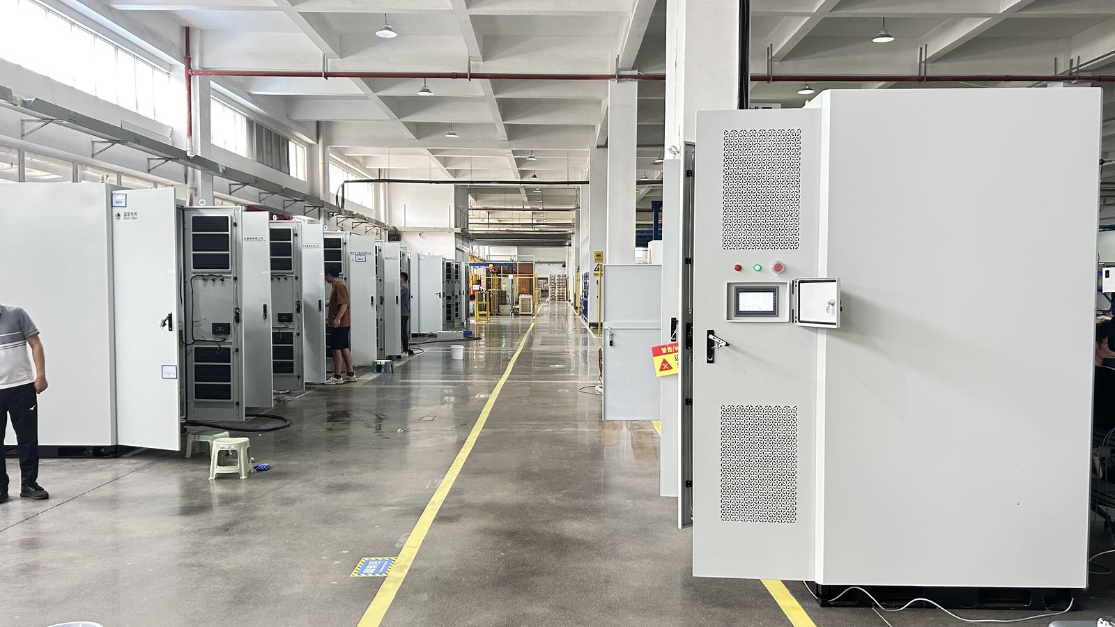 Commissioning hall with cabinets lined up on both sides, control doors open